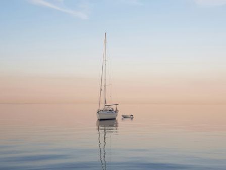 A lone sailboat rests on a glassy sea at sunrise, its reflection shimmering, with a calm, pastel sky above and soft, minimalist horizon.